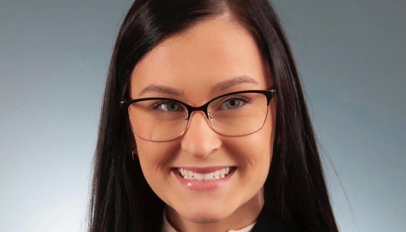 A Woman Wearing Glasses And Smiling At The Camera