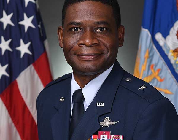 A Man Wearing A Suit And Tie Smiling At The Camera