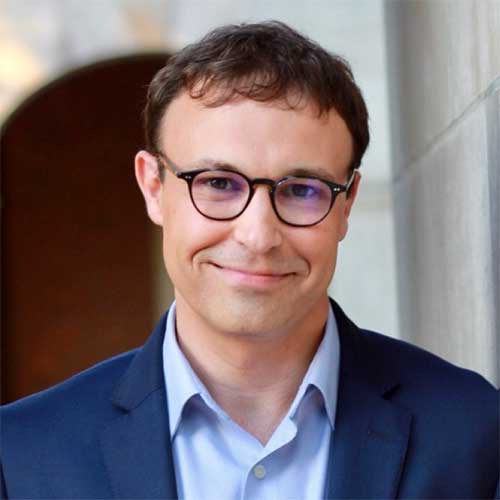 Michael Lamb wearing a suit and glasses