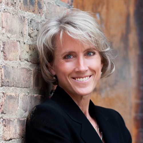 a woman standing in front of a brick building