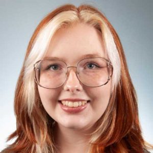 a close up of a woman wearing glasses and smiling at the camera