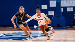 Women's basketball breaks away from the opposing team.