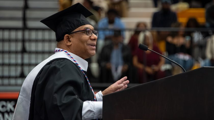 A Graduate In Cap And Gown Speaks At A Podium During Auburn University At Montgomery's Commencement.