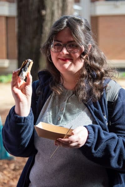 A student enjoying a s'more on Auburn University at Montgomery's quad during Warhawk Welcome Week.