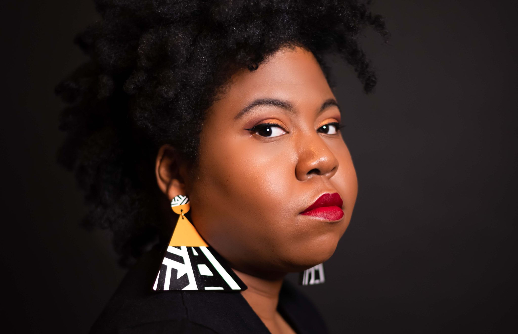 AUM portrait of a woman with natural hair, red lipstick, and bold geometric earrings at Auburn University at Montgomery