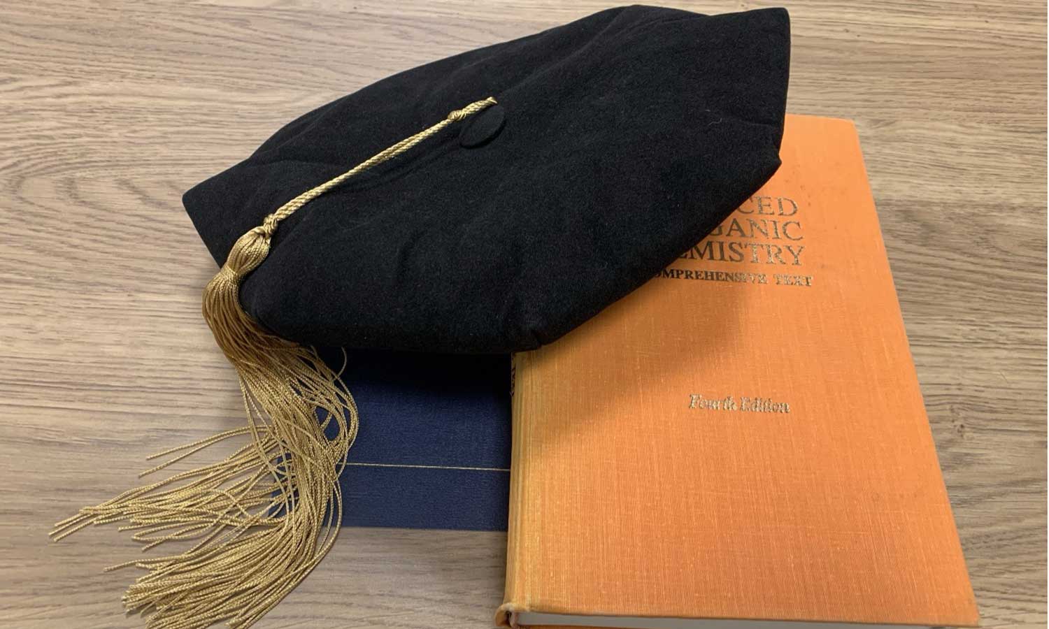 Chemistry-Scholarships-card-image Doctoral tam with gold tassel on chemistry textbooks at Auburn University at Montgomery, celebrating graduate success